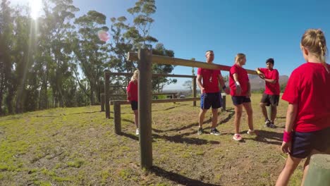 trainer assisting a school girl in fitness trail during obstacle course 4k