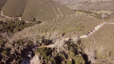 Line-of-4x4-trying-to-climb-extreme-off-road-training-course-track,-aerial-view
