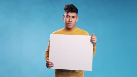 man looking at camera and smiles while holding blank white sign over an isolated background.