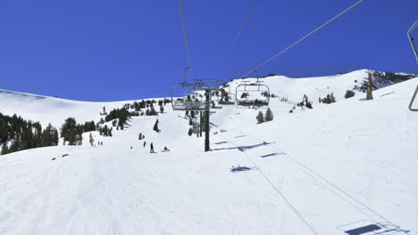 pov of someone  riding up a ski lift in the mountains