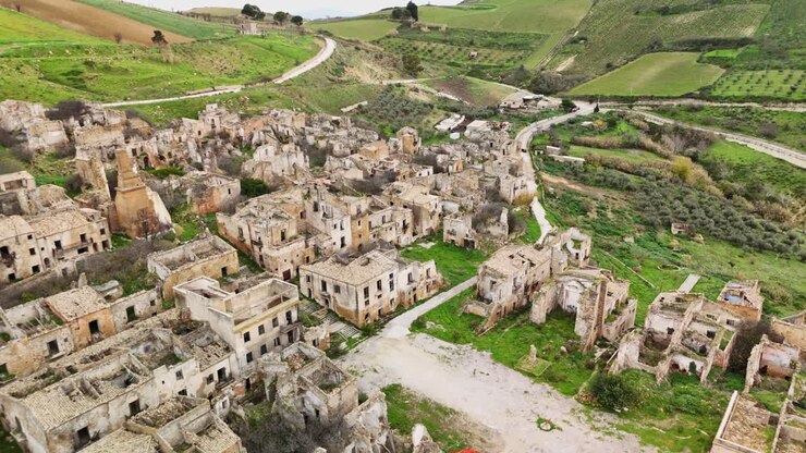 Vista aerea delle rovine di un villaggio abbandonato in un paesaggio lussureggiante che mostra la storia
