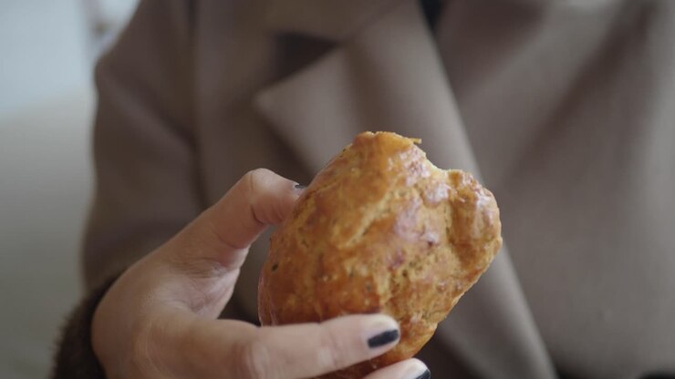 Close-Up of Hand Biting into a Savory Baked Good
