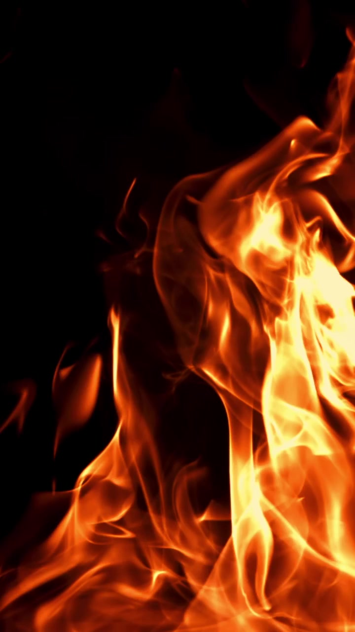 Fiamme arancioni brillanti che bruciano su uno sfondo nero