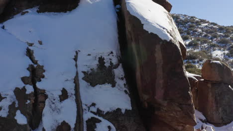 Rock-formation-under-the-snow,-winter-scene-in-Joshua-Tree-National-park,-orbiting-shot