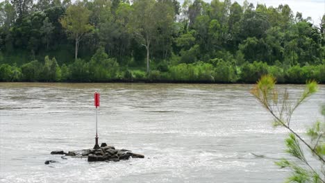 channel marker on rocks in glittering sunlight, in this australian outback river, flowing through the rainforest and jungle