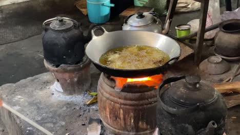 El-Proceso-De-Cocinar-Alimentos-Fritos-Como-Tofu,-Tempeh-En-Una-Sartén-Tradicional-Y-Una-Estufa-Usando-Carbón-Y-Una-Estufa