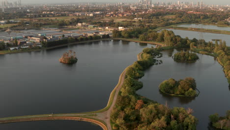 pan up aerial shot from walthamstow wetlands towards central london