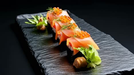 delicious salmon nigiri sushi pieces, garnished with vibrant red caviar and fresh dill, are elegantly arranged on a sleek black slate plate, creating a visually appealing culinary experience