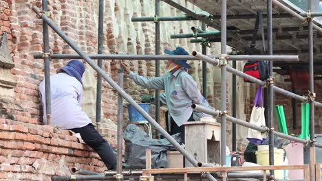 workers climbing and working on metal scaffolding