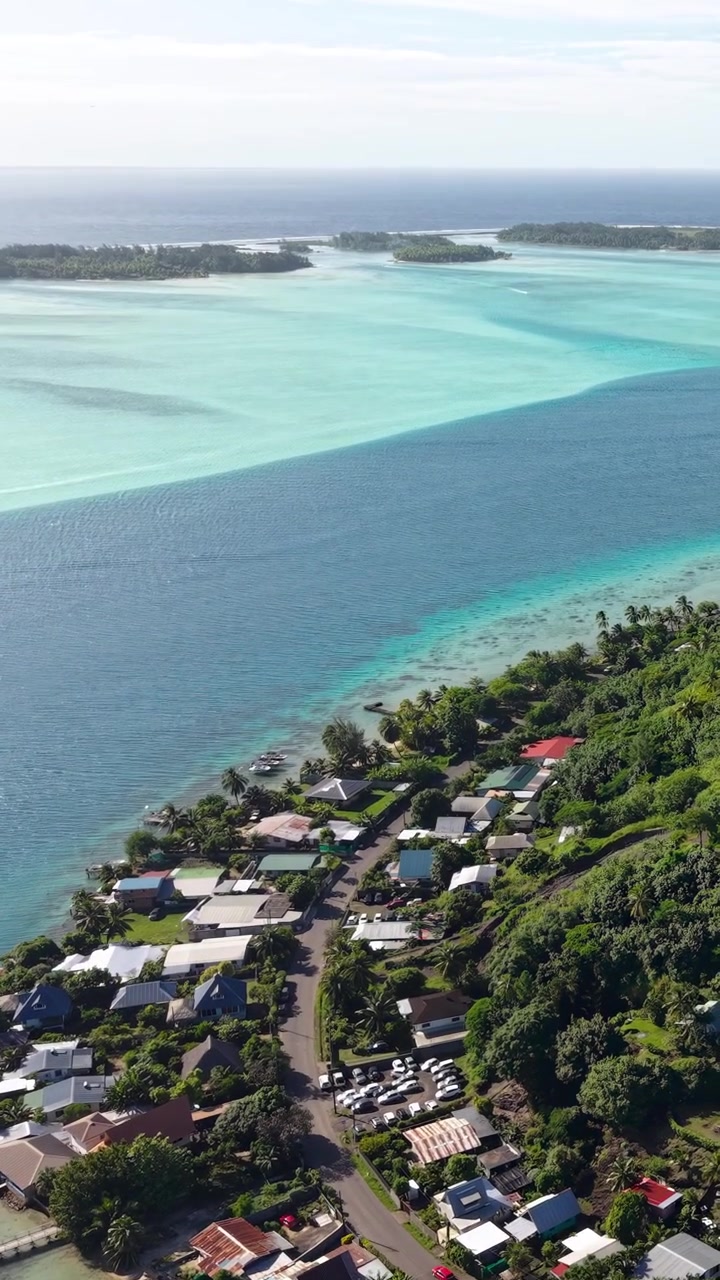 Bora Bora, French Polynesia. Drone View or Coastal Road, Houses and Turquoise Lagoon, Revealing Shot