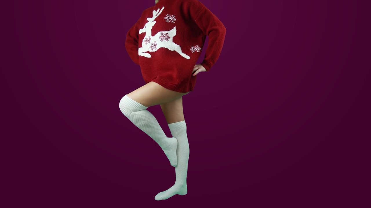 Ragazza che indossa calze bianche e balla con un maglione natalizio rosso. Incluso sfondo verde per cambio sfondo personalizzato ma anche uno sfondo bordeaux come esempio