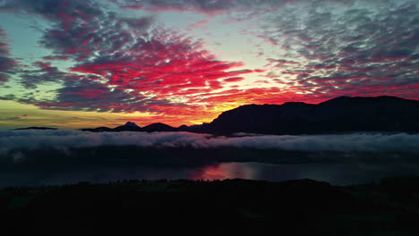 una toma lateral de un dron aéreo de una dramática puesta de sol roja en el lago attersee