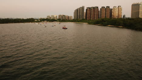 Drone-view-of-boats-on-the-waterfront-in-Hong-Kong-city,-China