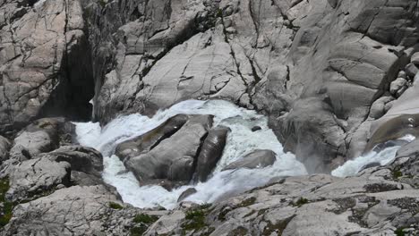 source of the rhone: small river at the top of the alps which crosses the rock and leaves the glacier, switzerland