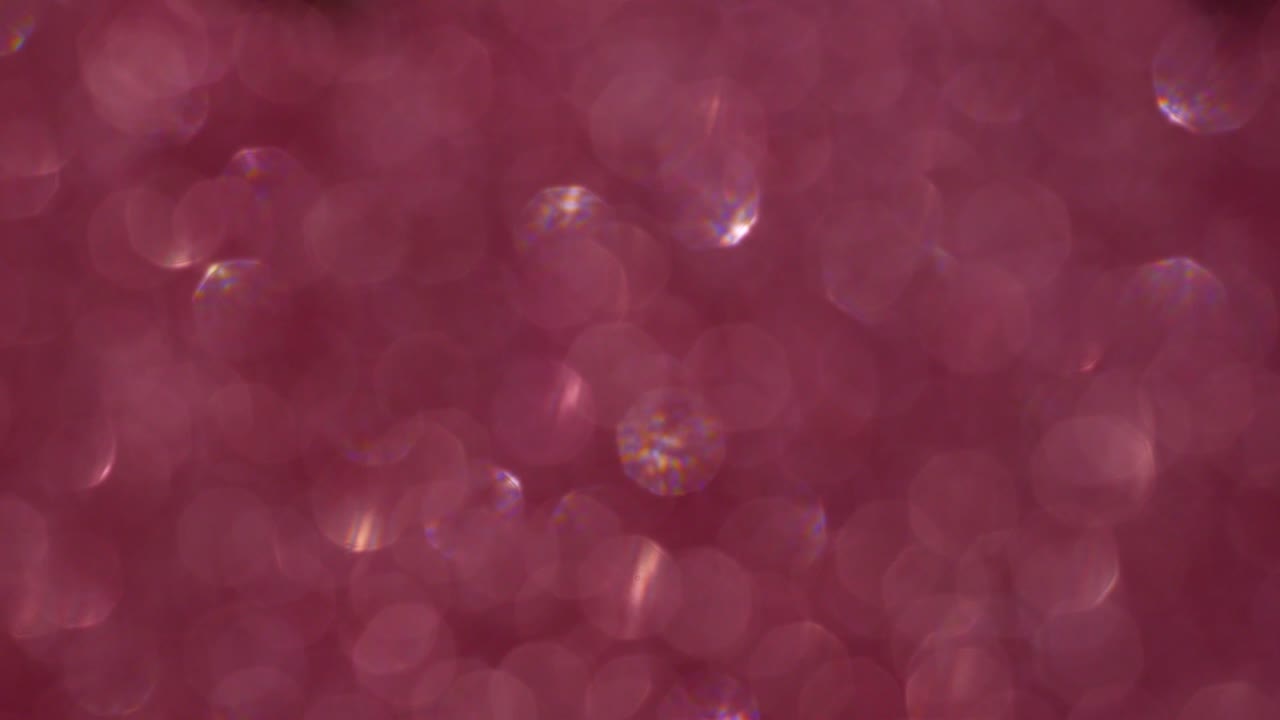 Trendy pink colors festive sparkling defocused lights. Red and purple bokeh 4K. Perfect stylish abstract overlay footage. Christmas New Year Valentine's day blinking flashing colorful background.