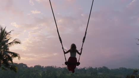 Mujer-Turista-Balanceándose-Sobre-La-Selva-Tropical-Al-Amanecer-Viaje-Chica-Disfrutando-De-Vacaciones-Exóticas-Sentada-En-Un-Columpio-Divirtiéndose-Estilo-De-Vida-De-Vacaciones-Libertad-4k