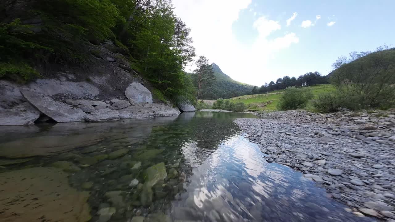 드론이 산의 강 위를 날아다닙니다.