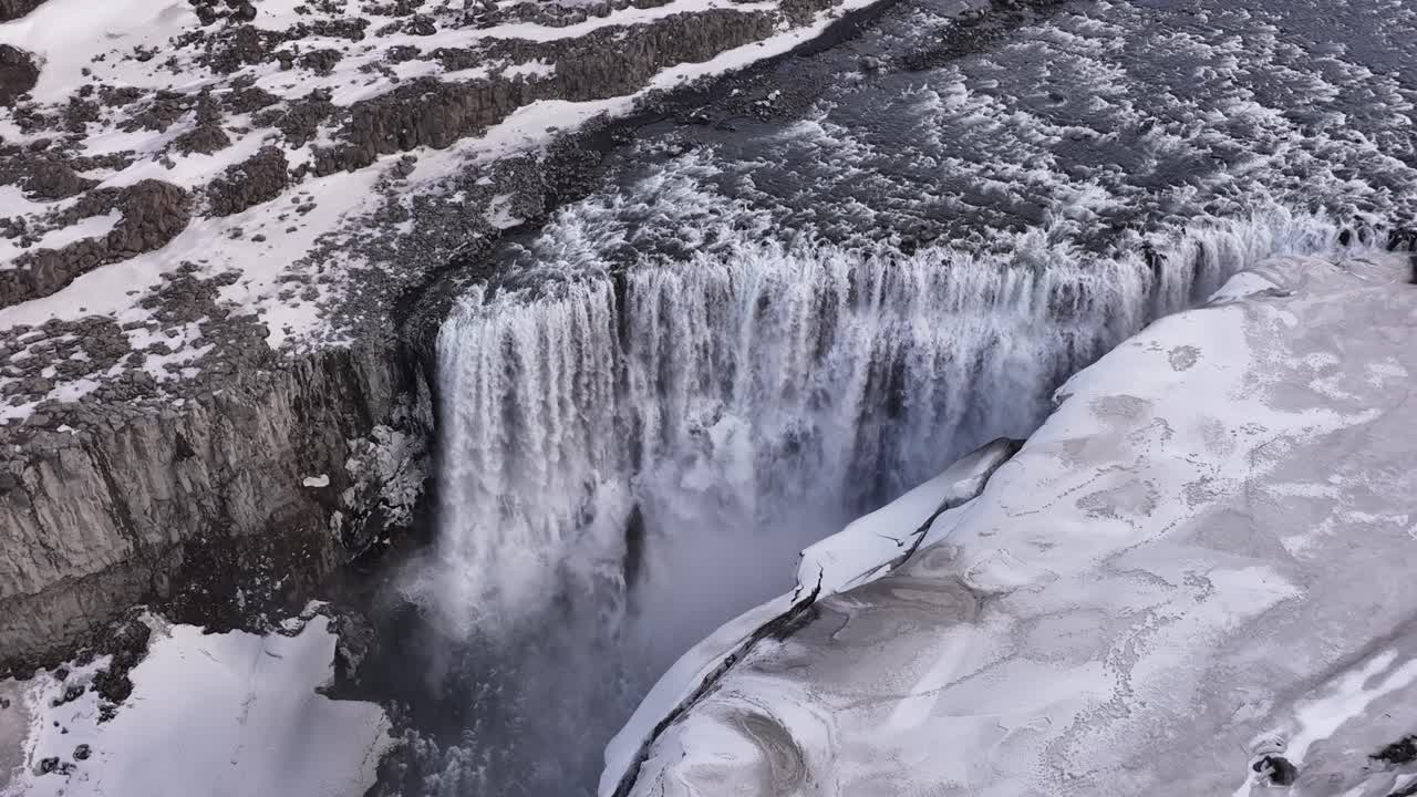 Majestic view of Dettifoss waterfall surrounded by ice and snow in Iceland
