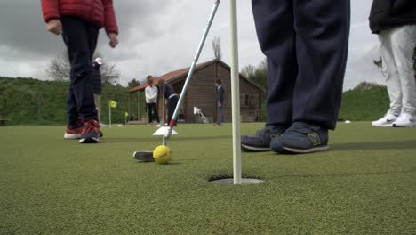 Kinder-Spielen-Golf-Auf-Einem-Feld