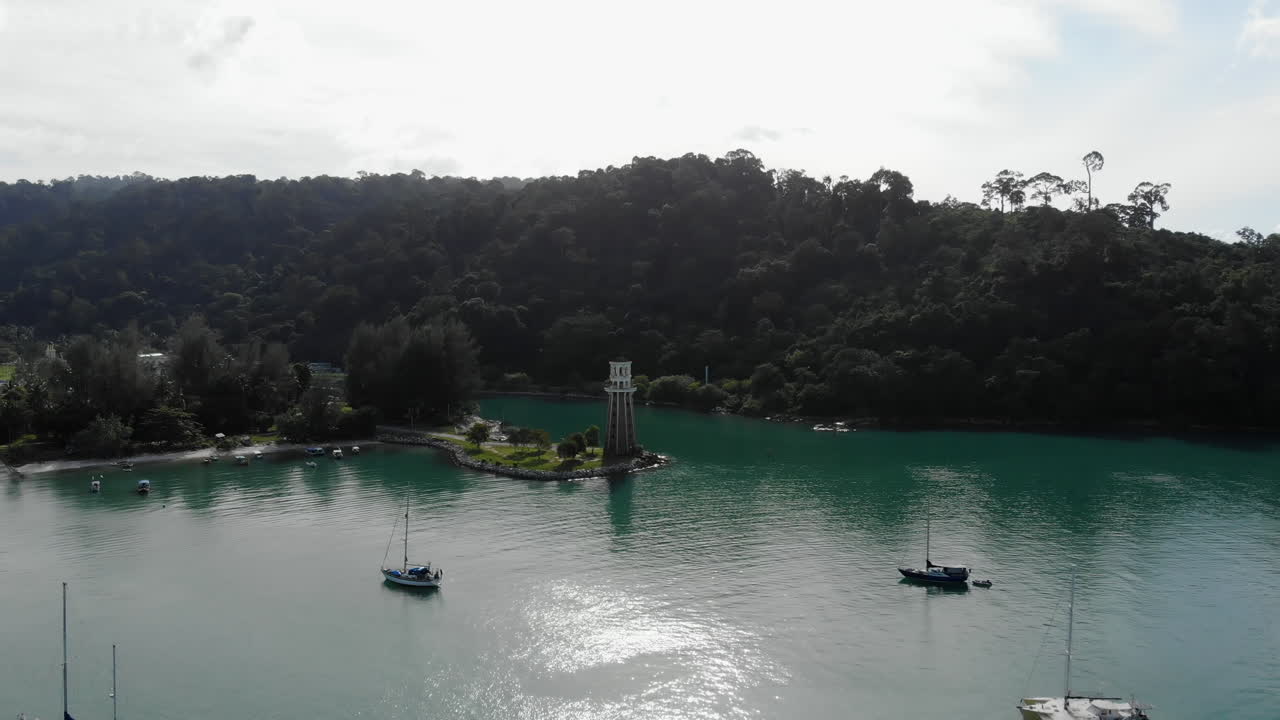 vista panorámica aérea de un faro junto al océano azul turquesa - puerto con barcos