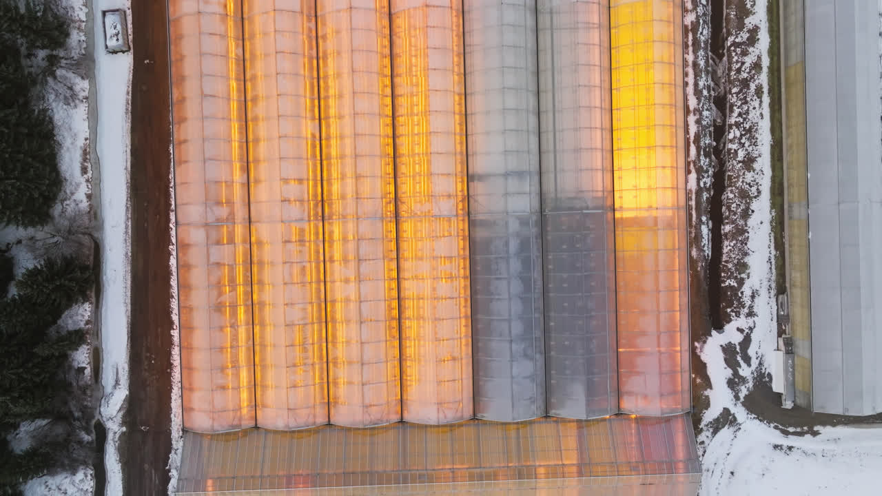 птичий глаз дрон выстрелил над освещенной теплицей в холодный зимний вечер