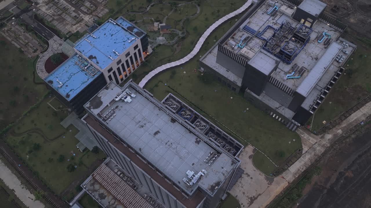 Luftfoto i kredsløb afslører et stort, moderne datacenterkompleks med avancerede kølesystemer. En udsigt over campusområdet og det omkringliggende område