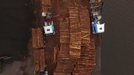 forestry and logging operations taking place in the highlands of scotland using large industrial machinery, ships and trucks