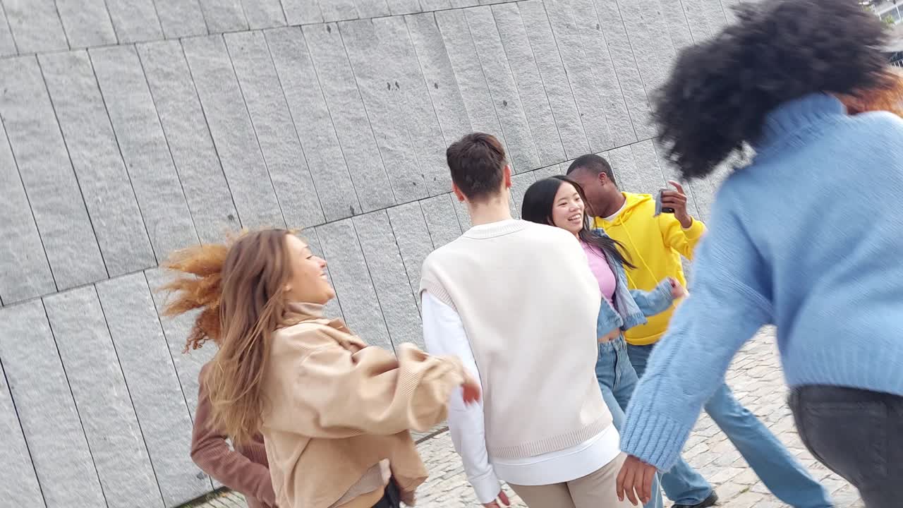 Urban multi-ethnic friends dancing happily in the street