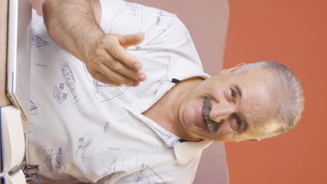 Vertical-video-of-Old-man-making-money-sign-with-his-hands.