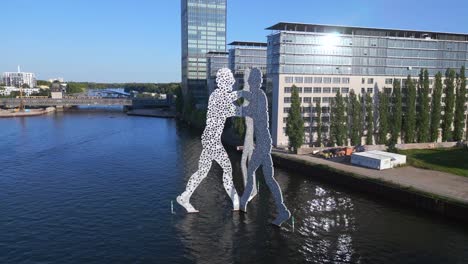 Stunning-aerial-top-view-flight-Molecule-Man-on-border-river-Spree,-east-Berlin-Germany-evening-summer-23