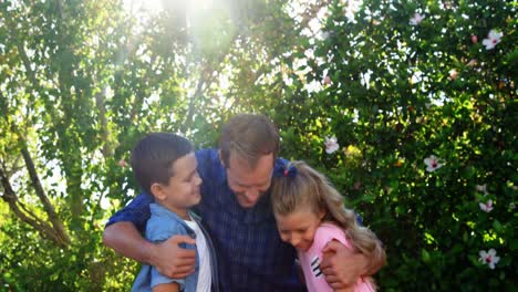 Father-embracing-his-kids-in-park