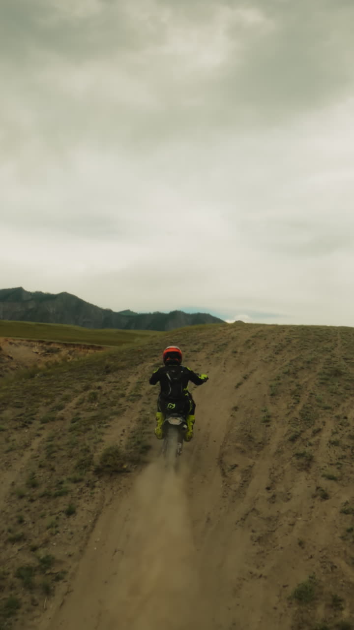 Sportsman rides motorcycle uphill fpv drone. Trained motorcyclist on professional vehicle conquers slope at motocross racing. Extreme leisure