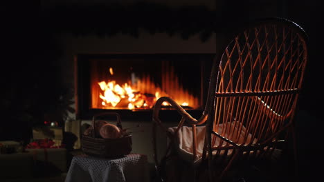 an empty rocking chair sways by the fireplace next to a set for needlework