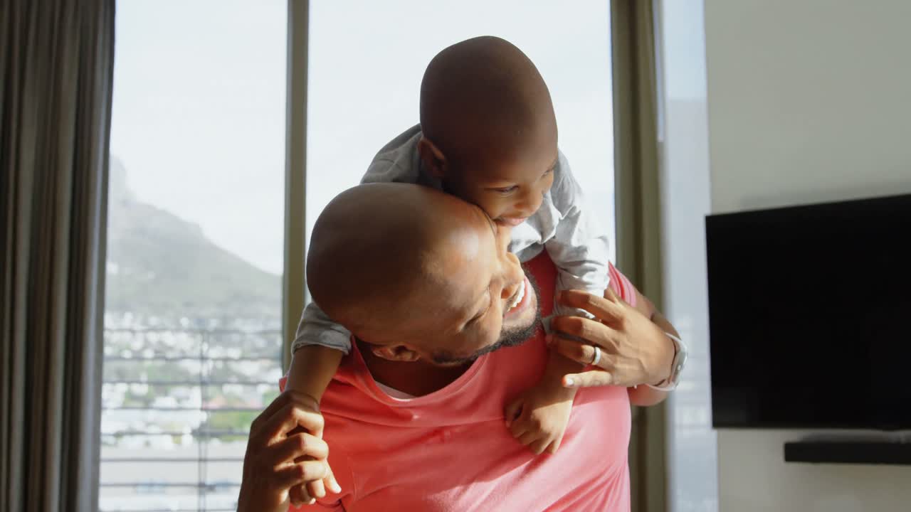 Father giving his son a piggyback in a comfortable home 4k