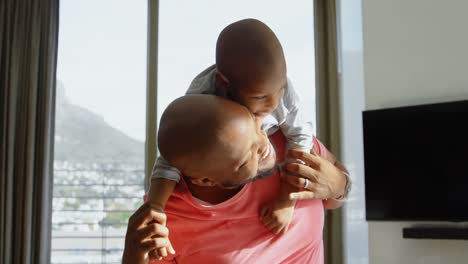 father giving his son a piggyback in a comfortable home 4k