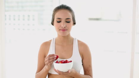 Mujer-Joven-En-Forma-Comiendo-Un-Plato-De-Fresas