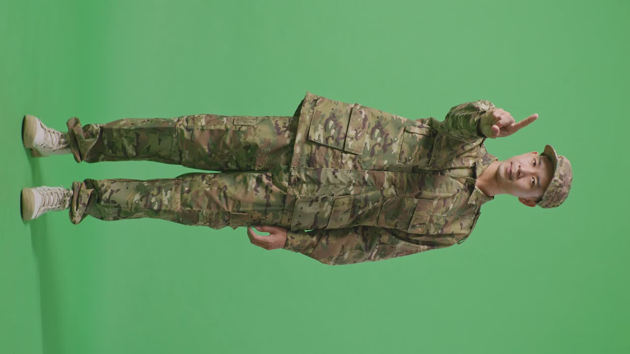 Full Body Of Asian Man Soldier Pointing At You And Disapproving With No Index Finger Sign While Standing In The Green Screen Background Studio