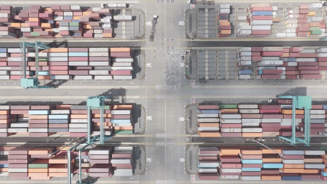 Top down aerial shot of Tanjung Pelepas port as the drone ascends revealing stacked containers captured in dlog m color profile