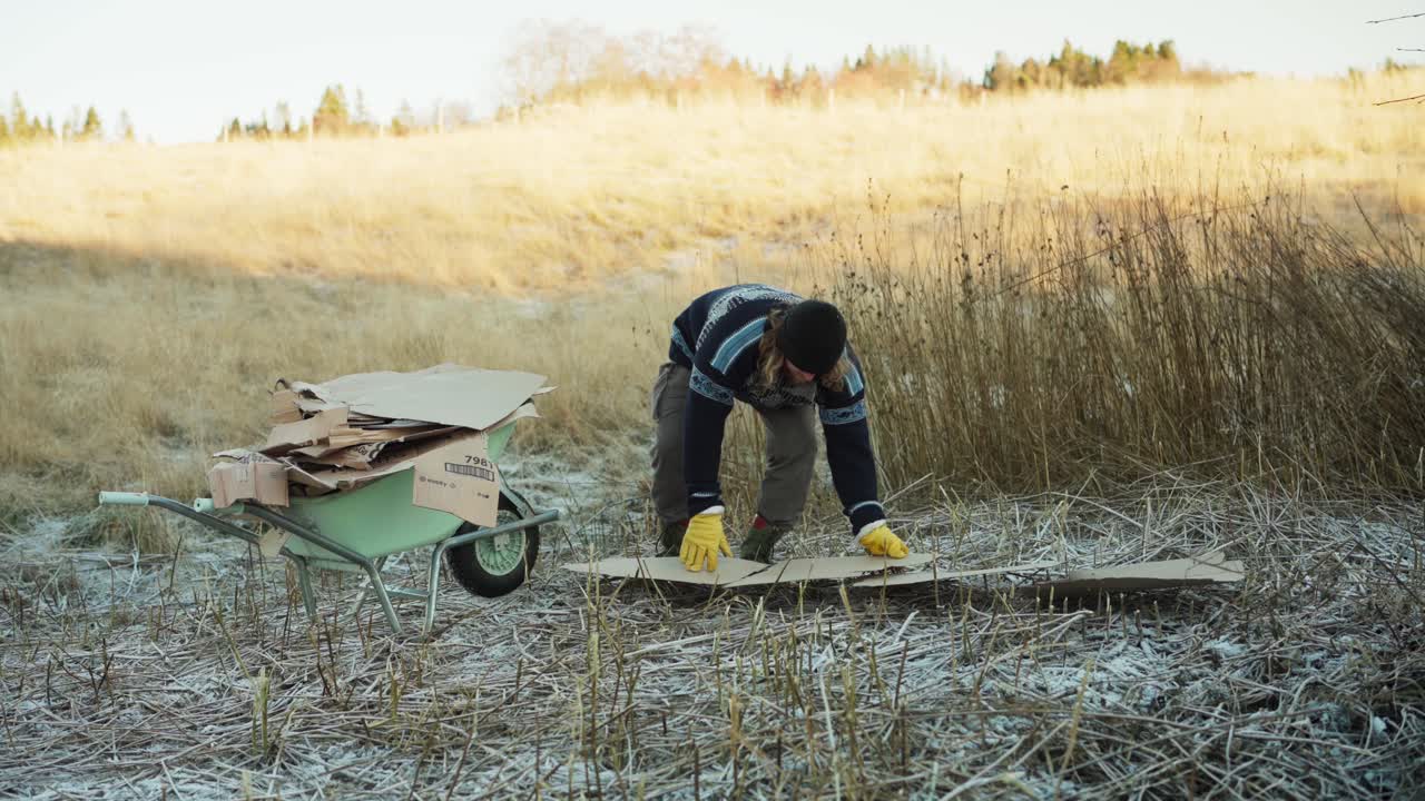 한 사람 이 카드보드 를 밀치 로 사용 하기 위해 준비 하고 있으며, 그 의 개 는 그 와 함께 있다 - 정적