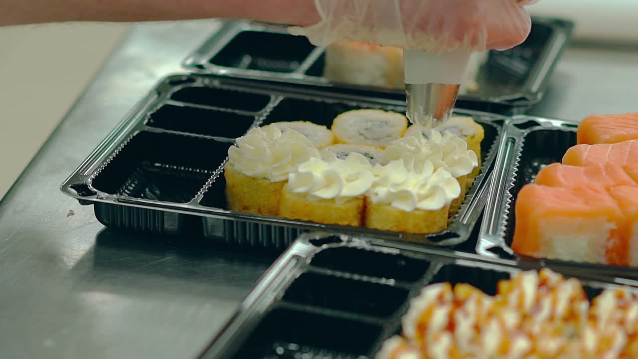 요리사는  ⁇ 긴 오멜 ⁇ 과 함께 일본 롤에  ⁇  크림을 첨가합니다.