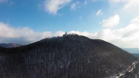 Vuelo-Aéreo-Hacia-Y-Panoramización-Del-Castillo-Medieval-De-Teck-En-Una-Montaña-En-Un-Día-De-Nieve-Durante-El-Invierno-En-Suabia,-Alemania