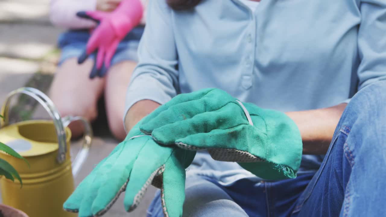 madre e hija poniendo guantes antes de la jardinería