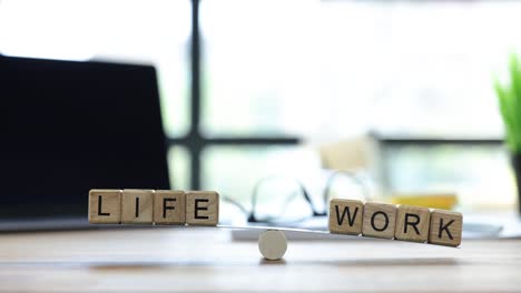 wooden blocks spelling life and work on a balancing scale