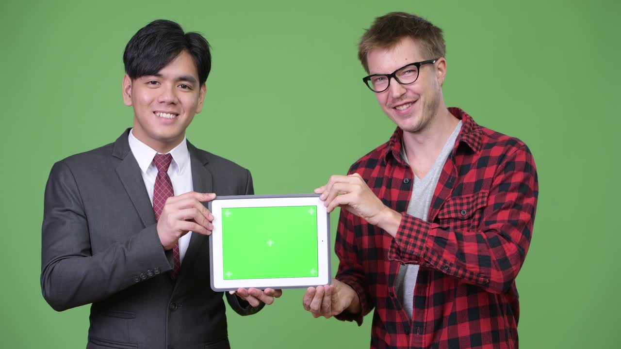 젊은 잘생긴 아시아 사업가와 젊은 스칸디나비아 사업가가 함께 일하고 있습니다.