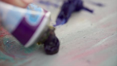 applying purple paint to a painting palette