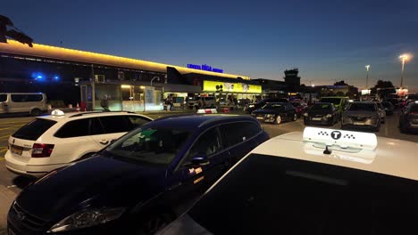 taxis and cars at riga airport terminal at dusk