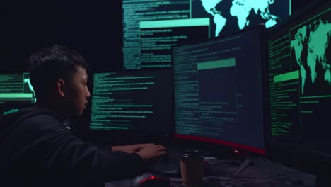 asian boy hacker hacking with multiple computer screens in dark room