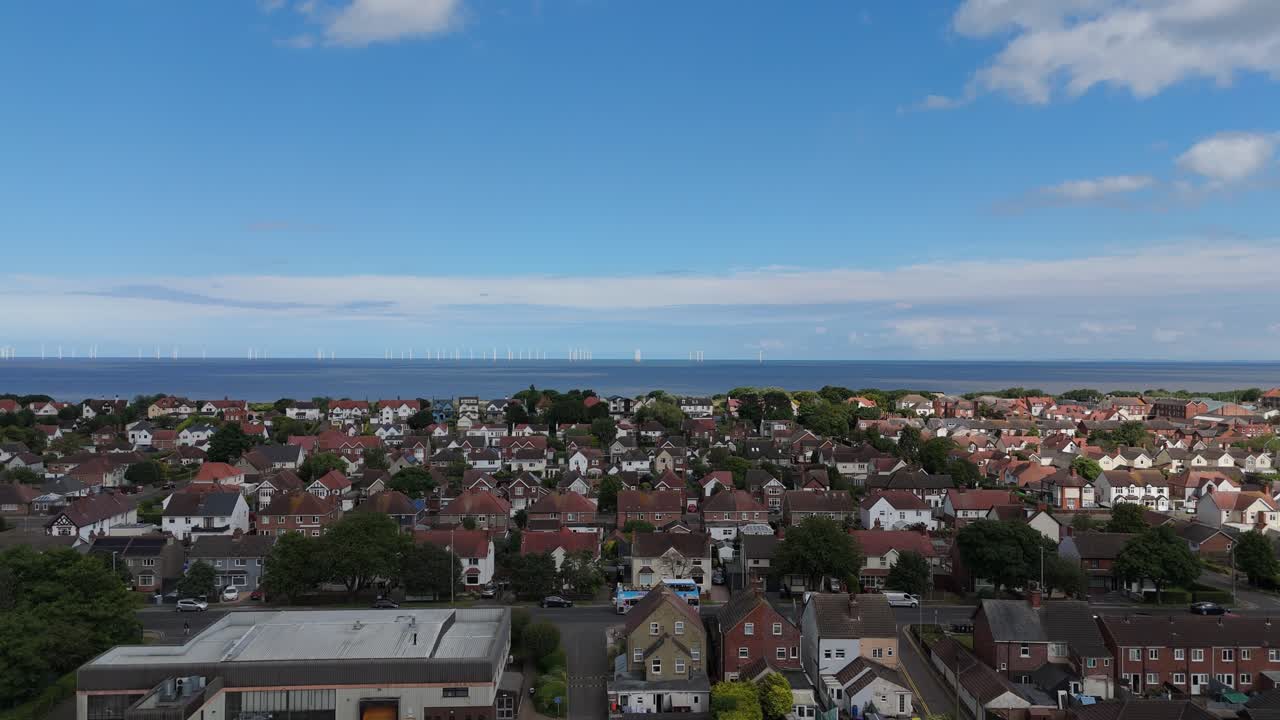 Aerial View of a Coastal Residential Area with Wind Turbines
