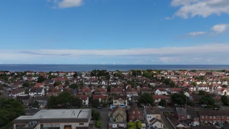 aerial view of a coastal residential area with wind turbines