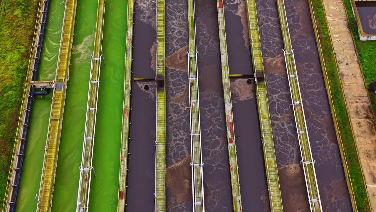 Water treatment facility processing sewage at evening with different stages of purification visible from above